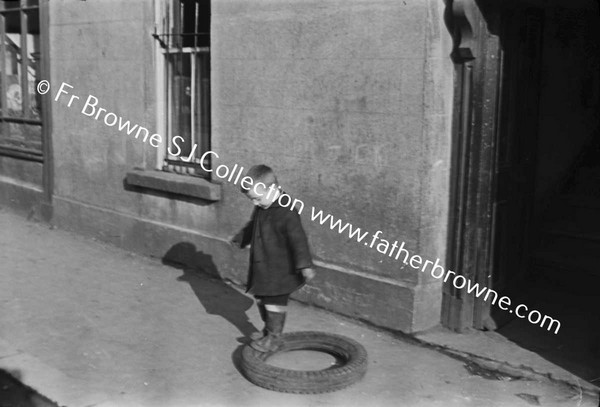 CHILD PLAYING WITH TYRE